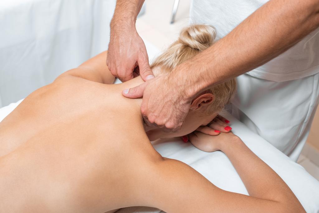 Hombre terapeuta haciendo masaje de cuello a mujer en salón de belleza
  - Foto, imagen