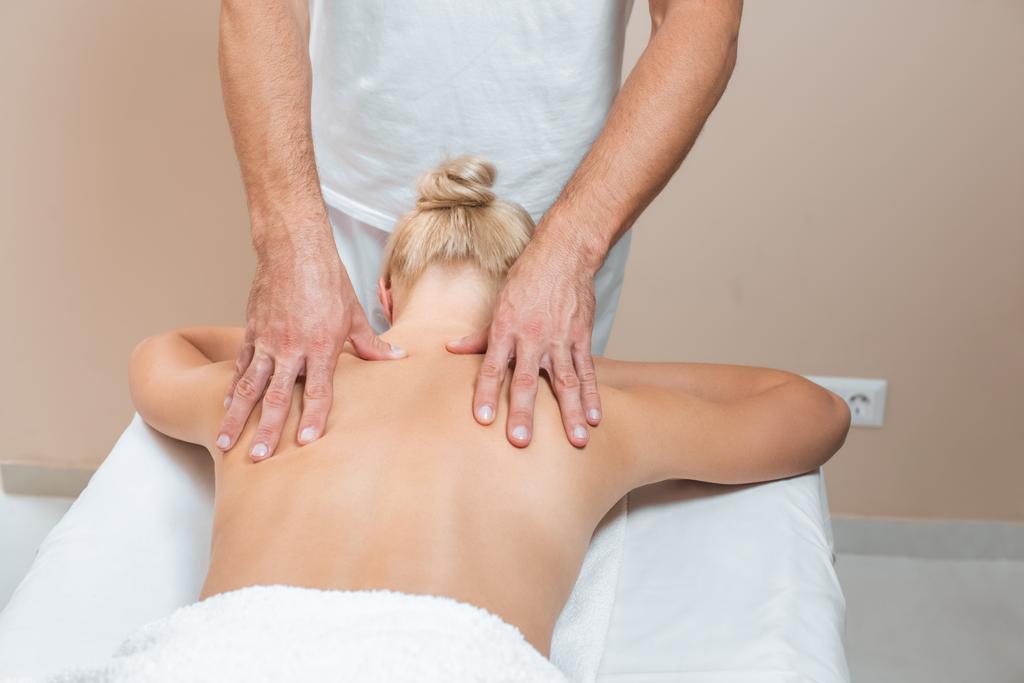 Чоловік масажист робить масаж спини жінці в спа-кімнаті
 - Фото, зображення