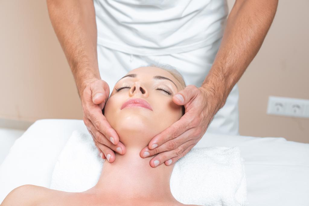 Mannelijke therapeut doen gezicht massage voor vrouw in de beauty salon - Foto, afbeelding