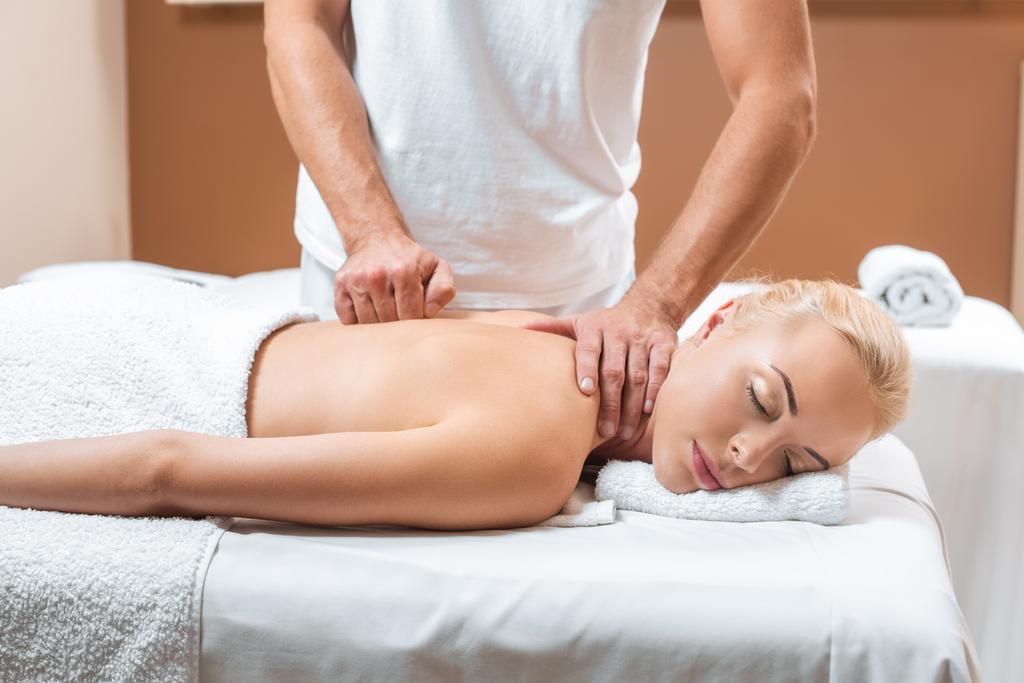 massagista do sexo masculino fazendo massagem para mulher bonita com olhos fechados no spa
 - Foto, Imagem