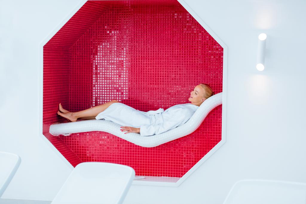 Blondine liegt auf weißem Liegestuhl im Mosaik-Achteck - Foto, Bild
