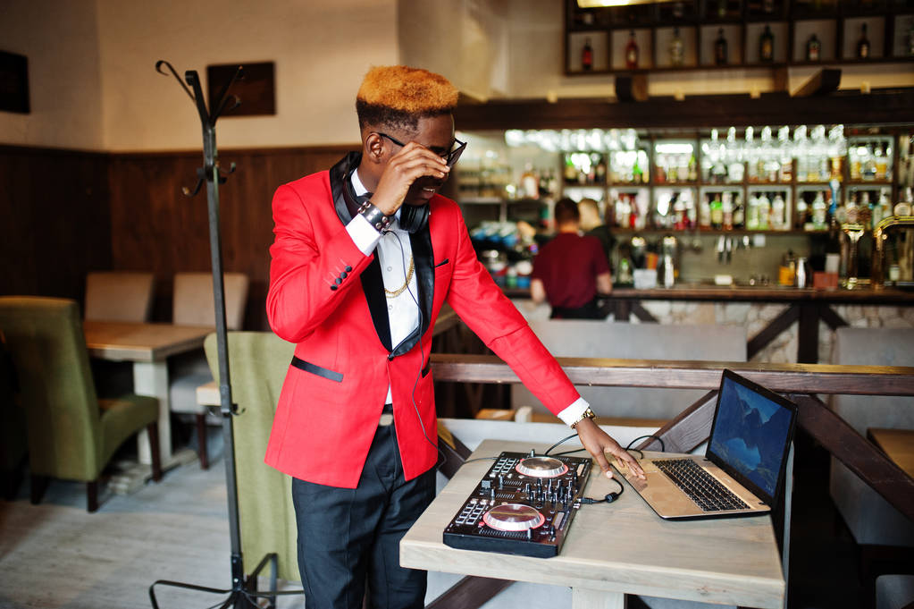 Мода афроамериканський чоловік модель DJ на червоному костюмі з контролером DJ
.  - Фото, зображення
