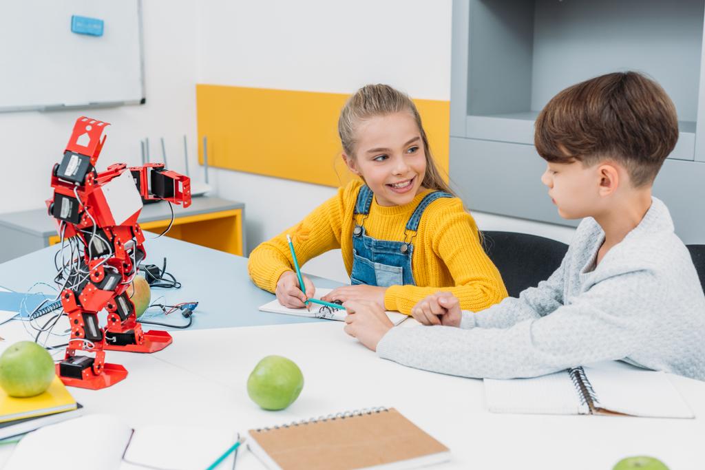 χαρούμενα παιδιά σχολικής ηλικίας μιλώντας στο μάθημα ρομποτική βλαστικών - Φωτογραφία, εικόνα