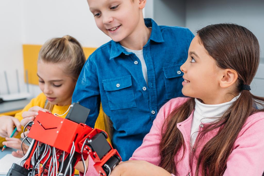 Close-up van schoolkinderen met handgemaakte elektrische robot in de klasse van de stam - Foto, afbeelding