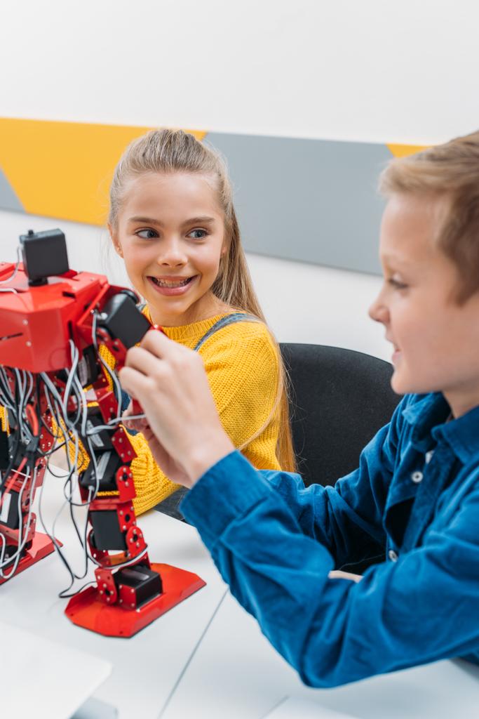 sorridenti scolari che programmano robot insieme durante la classe educativa STEM
 - Foto, immagini