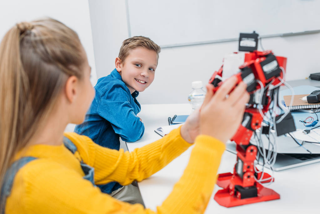 schoolchildren programming robot together during STEM educational class - Photo, Image