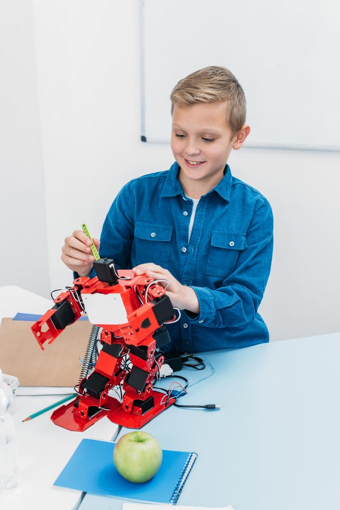 scolaro felice che lavora sul modello robot fatto a mano durante la lezione STEM
   - Foto, immagini