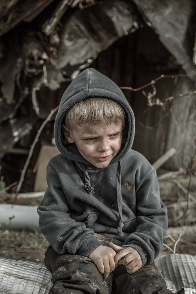 Бездомный грязный мальчик плачет в заброшенной деревне
 - Фото, изображение