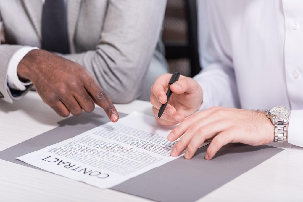 Weergave van multiculturele zakenlieden ondertekening contract bij Bureau bijgesneden  - Foto, afbeelding