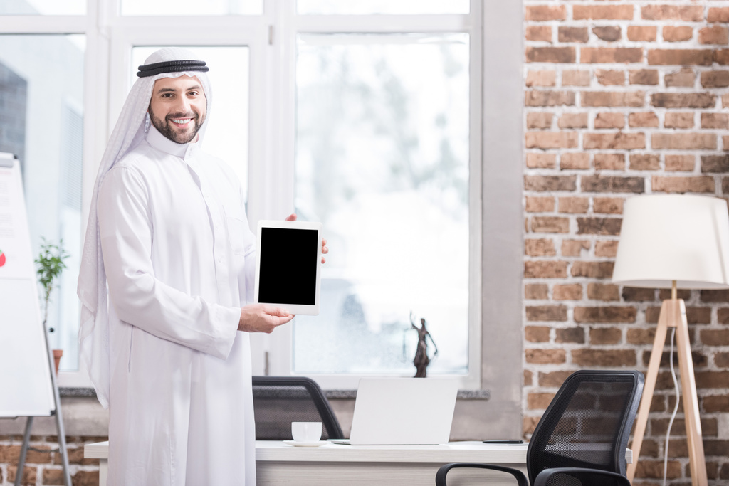 Αραβική επιχειρηματίας κρατώντας ψηφιακή δισκίο στο σύγχρονο γραφείο  - Φωτογραφία, εικόνα