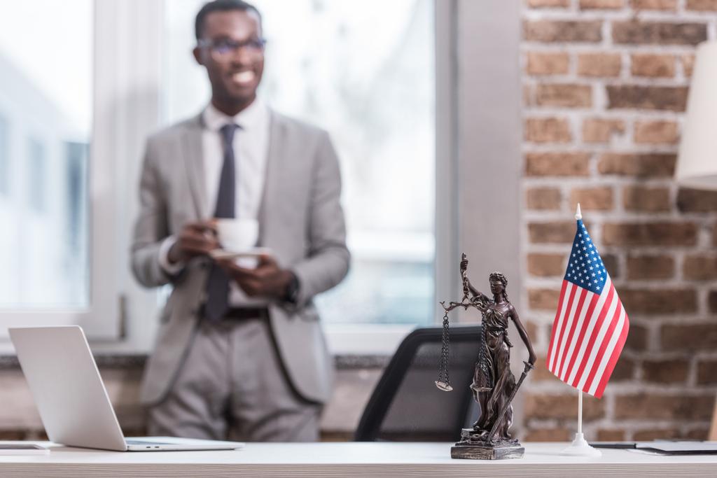 Toimistopöytä ja esineitä afrikkalainen amerikkalainen liikemies taustalla
  - Valokuva, kuva