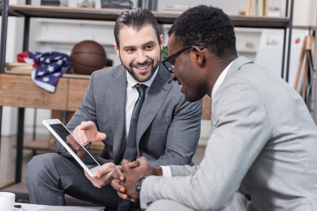 Африканский американский бизнесмен ищет бизнес-партнеров цифровой планшет в офисе
 - Фото, изображение