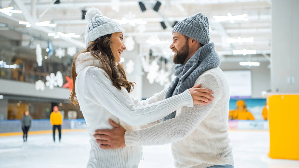 vista lateral de casal romântico sorridente na pista de patinação
 - Foto, Imagem
