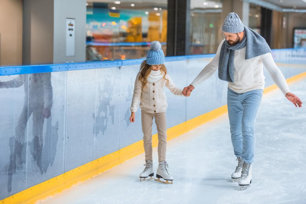 apa és lánya együtt korcsolyázni a jégpálya kötött pulóverek - Fotó, kép