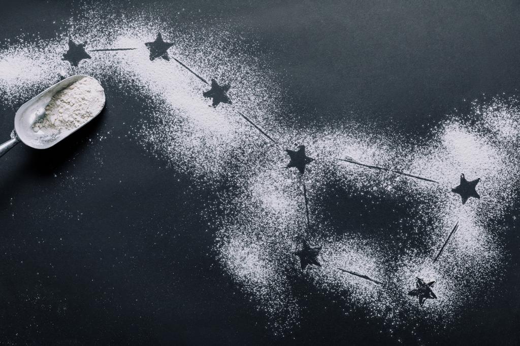 vista elevada de colher na mesa coberta de farinha com estrelas como constelação grande mergulhador
  - Foto, Imagem