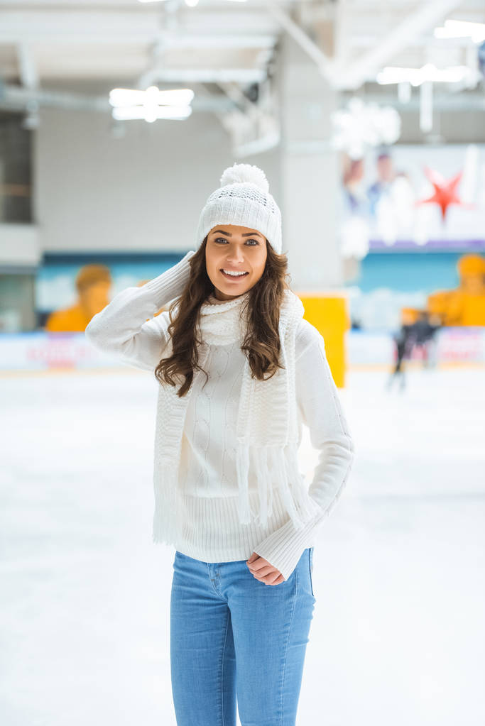 retrato de mujer joven feliz mirando a la cámara mientras patina en pista de hielo
 - Foto, Imagen