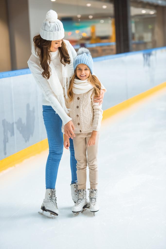 smiling kid and mother on skating rink - Photo, Image
