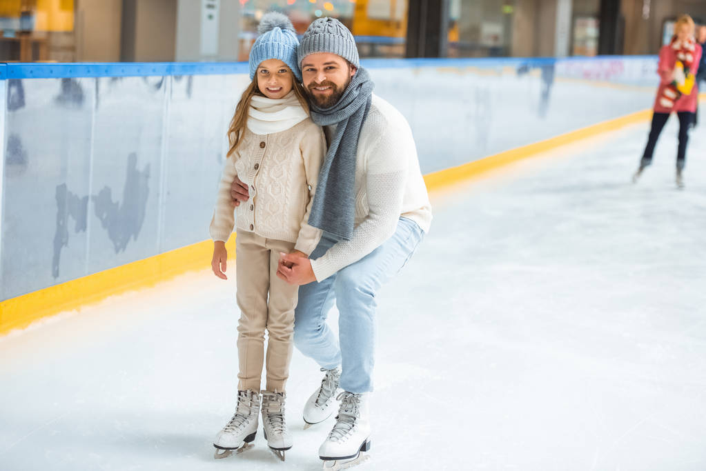 gelukkig weinig dochter en vader op ijsbaan - Foto, afbeelding