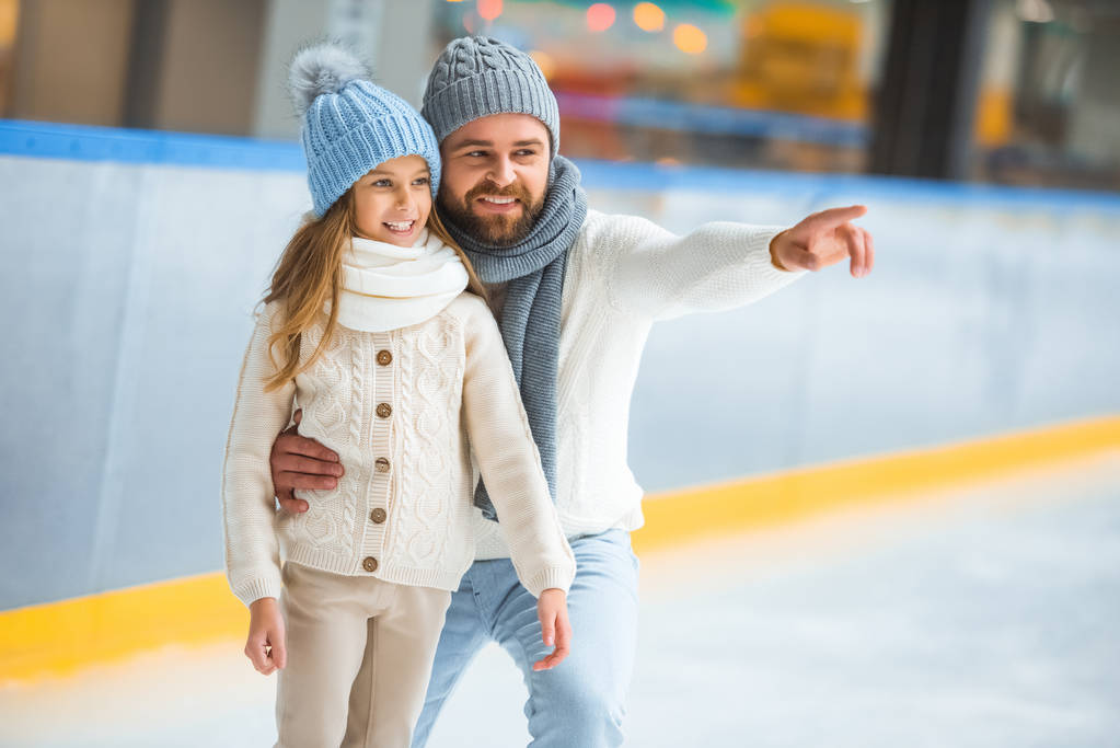 Glückliche kleine Tochter und Vater auf der Eisbahn - Foto, Bild