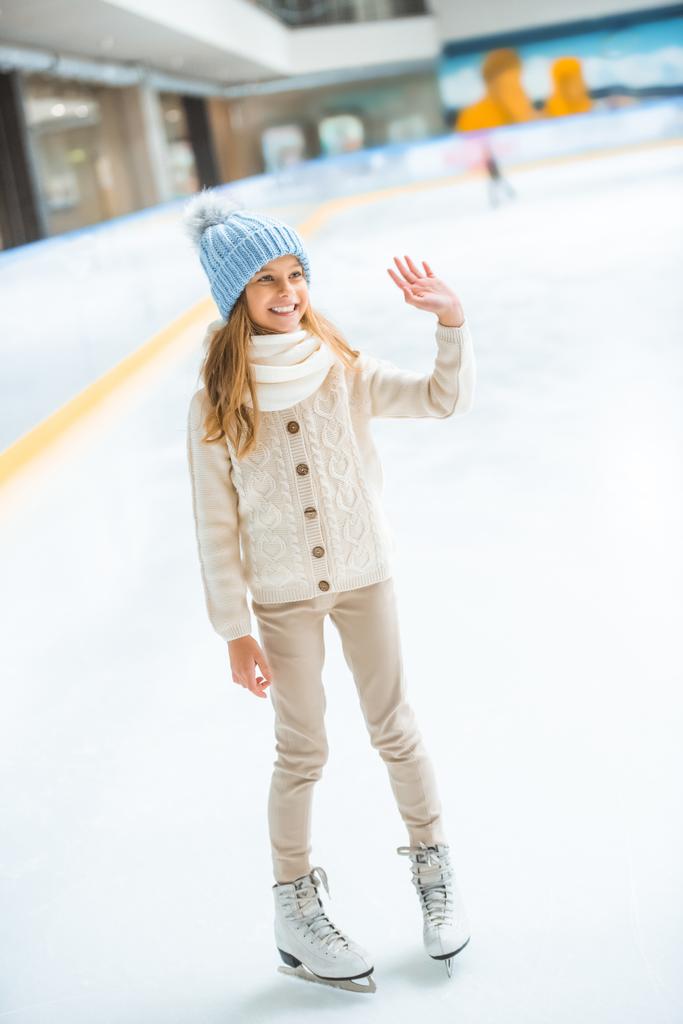 весела дитина в светрі і ковзанах вітає когось на ковзанах
 - Фото, зображення