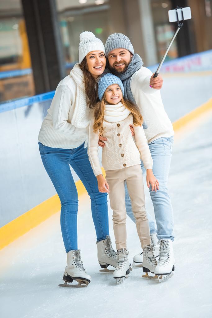 famille souriante prendre selfie sur smartphone sur patinoire
 - Photo, image