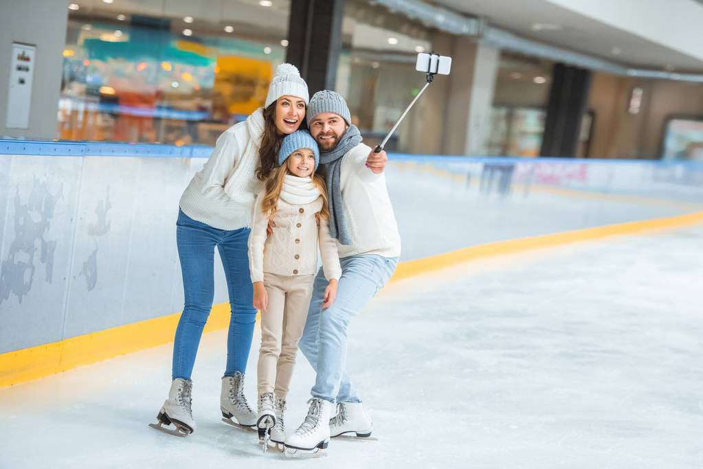 família sorrindo tirar selfie no smartphone na pista de patinação
 - Foto, Imagem