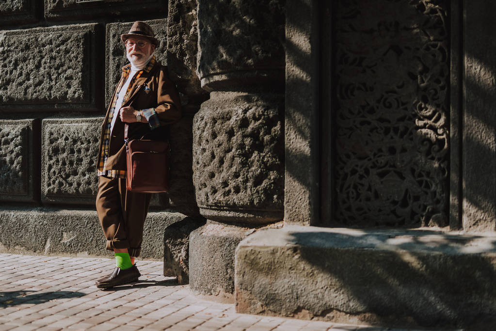 Hipster fröhlicher alter Mann lehnt an Gebäude - Foto, Bild