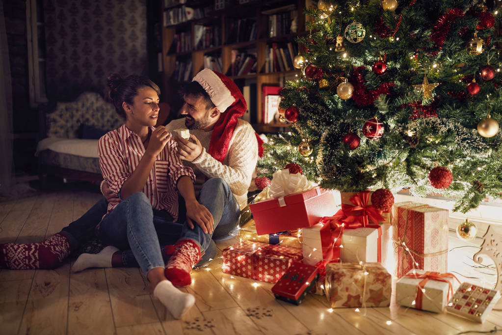 pari avaamalla lahjoja kiiltävä joulukuusi
 - Valokuva, kuva