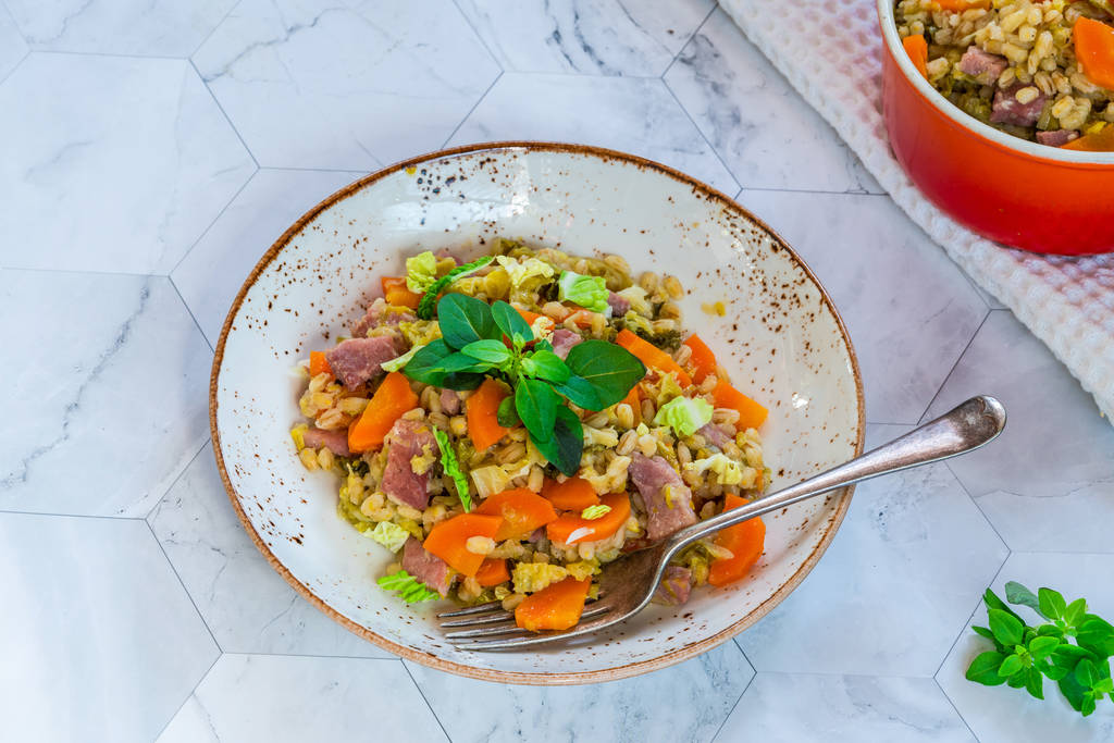 Pearl barley and bacon cassarole with carrots, leek and savoy cabbage - high angle view - Photo, Image