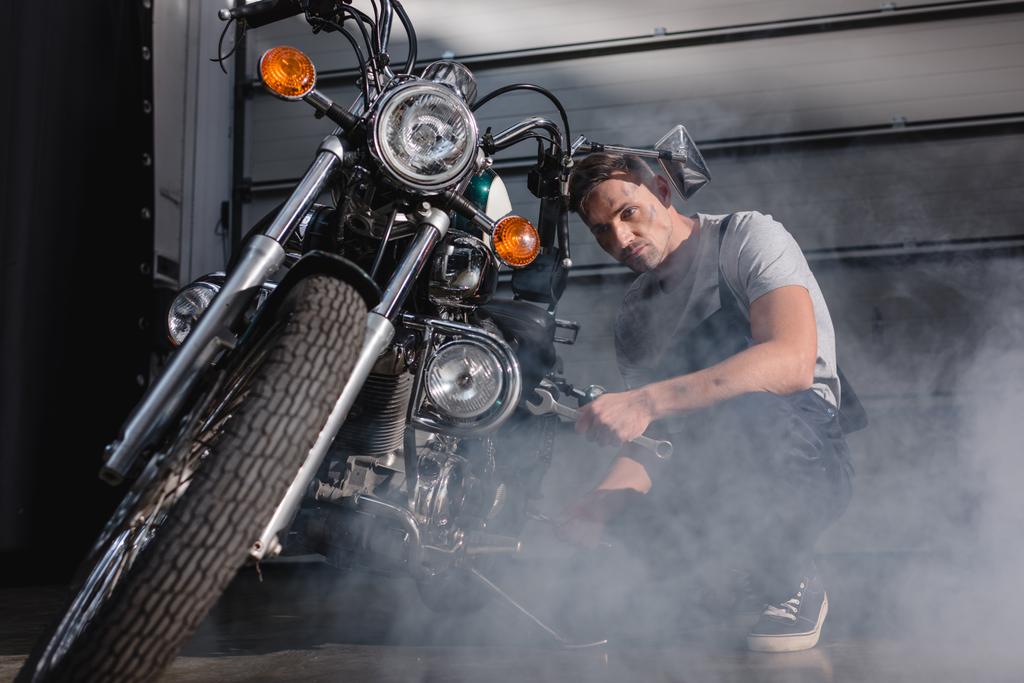 monteur vaststelling motorfiets voorwiel in garage - Foto, afbeelding