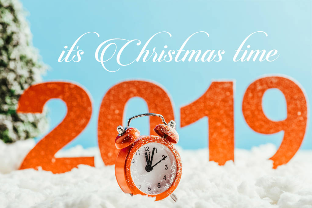 grandi numeri rossi 2019 con sveglia vintage in piedi sulla neve su sfondo blu con scritte "è tempo di Natale"
 - Foto, immagini