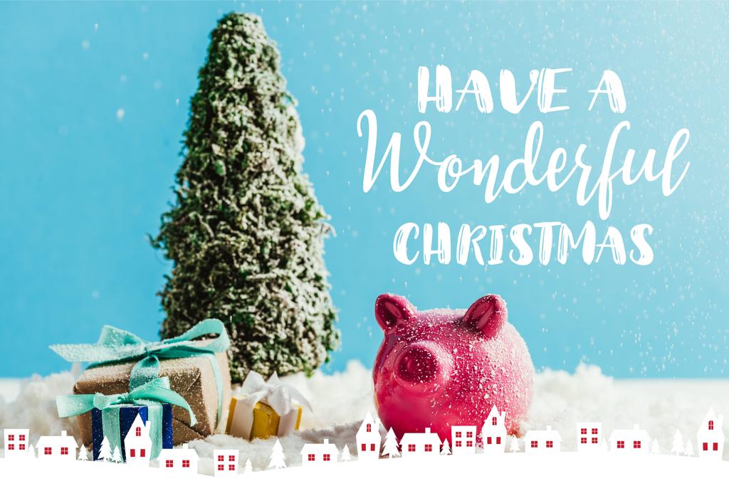 ミニチュア クリスマス ツリー ギフトと貯金とインスピレーションを「素晴らしいクリスマスを持っている」と青の背景に雪の上に立って家の図 - 写真・画像