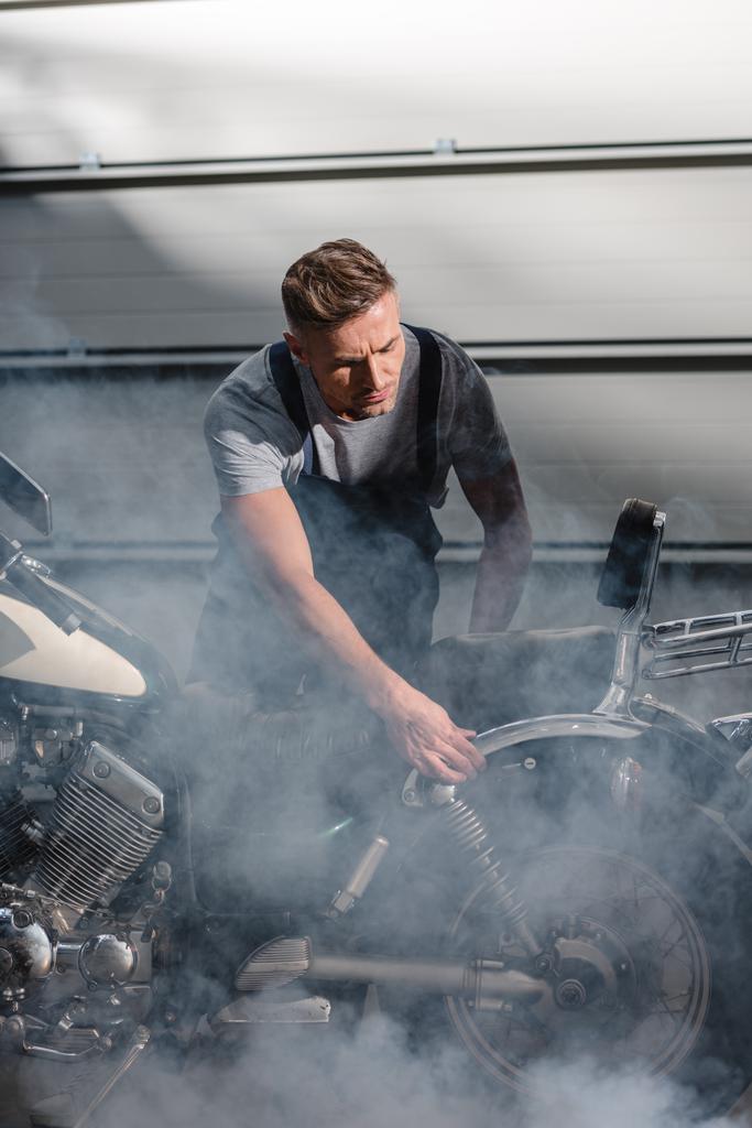 mekaanikko tarkistaa moottoripyörän moottori autotallissa
 - Valokuva, kuva