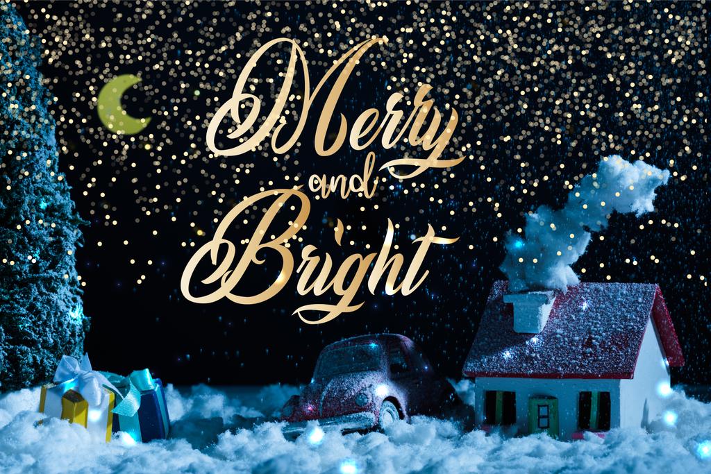 primo piano di auto giocattolo con regali di Natale e casa coperta di neve di notte, con scritte "allegre e luminose"
 - Foto, immagini
