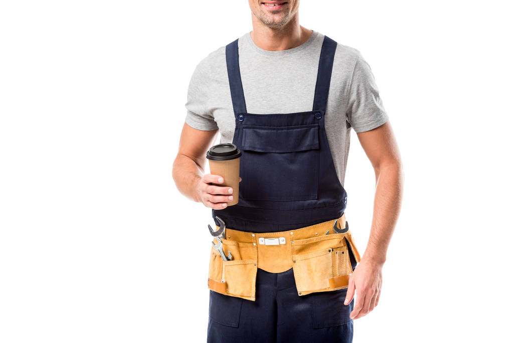 частковий вид на працівника з поясом інструментів, який п'є каву, щоб ізольовано на білому
 - Фото, зображення