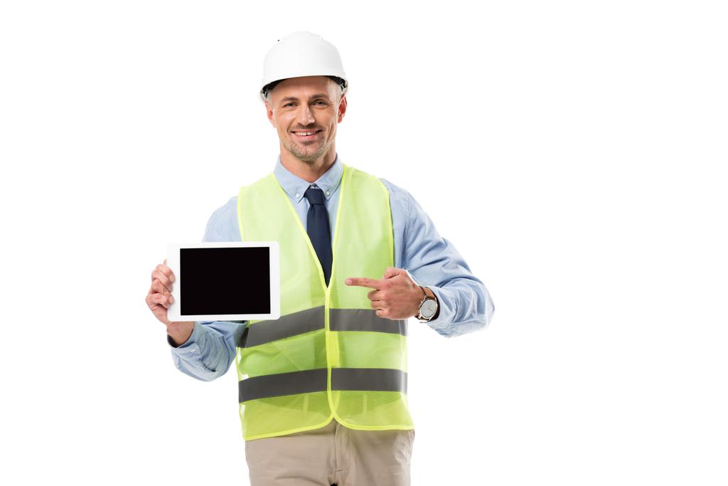 ingeniero sonriente apuntando con el dedo a la tableta digital con pantalla en blanco aislado en blanco
 - Foto, imagen