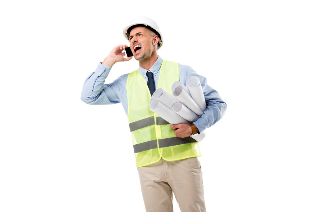 θυμωμένος μηχανικός κρατώντας σχεδιαγράμματα, μιλώντας στο smartphone και φωνάζοντας απομονωθεί σε λευκό - Φωτογραφία, εικόνα