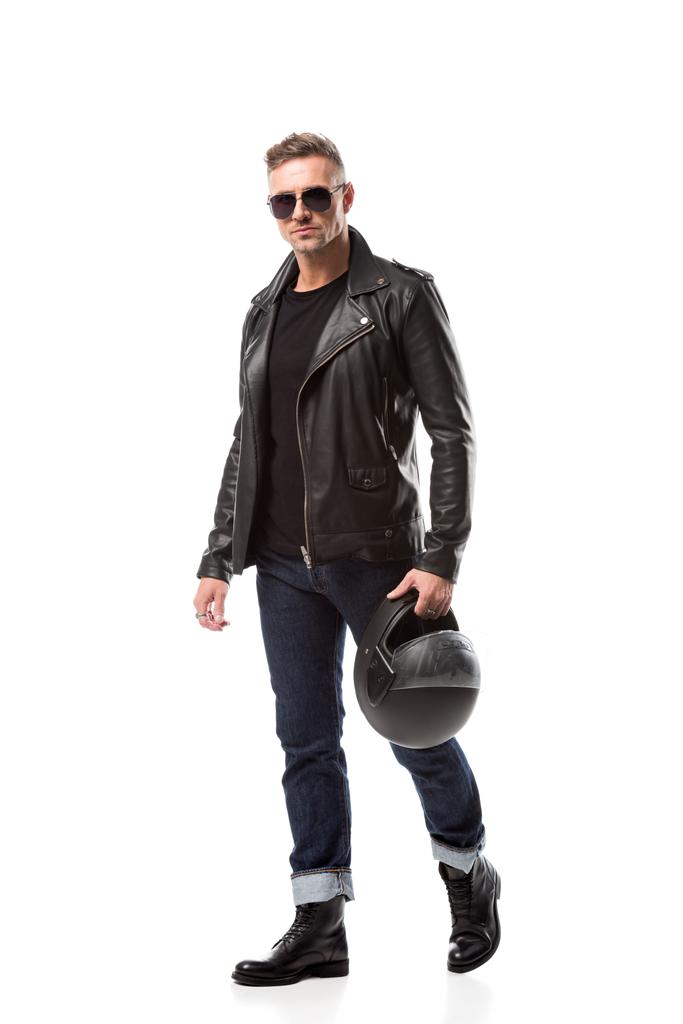 przystojny mężczyzna w skórzanym płaszczu i trzymając kask motocykl na białym tle okulary przeciwsłoneczne - Zdjęcie, obraz