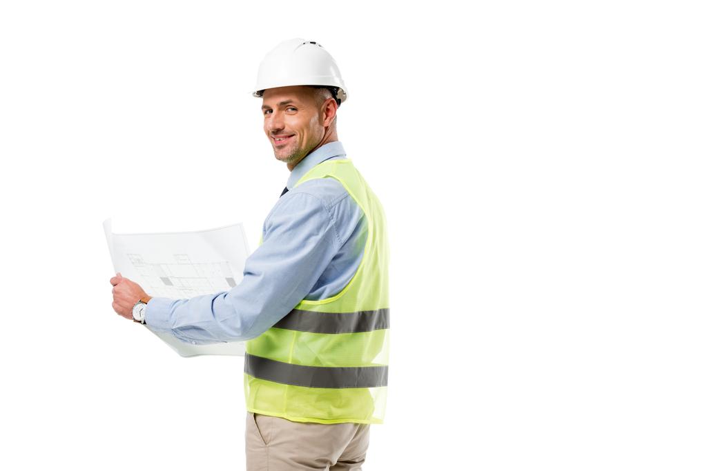 инженер в шлеме, смотрящий в камеру и держащий чертеж изолированный на белом
 - Фото, изображение