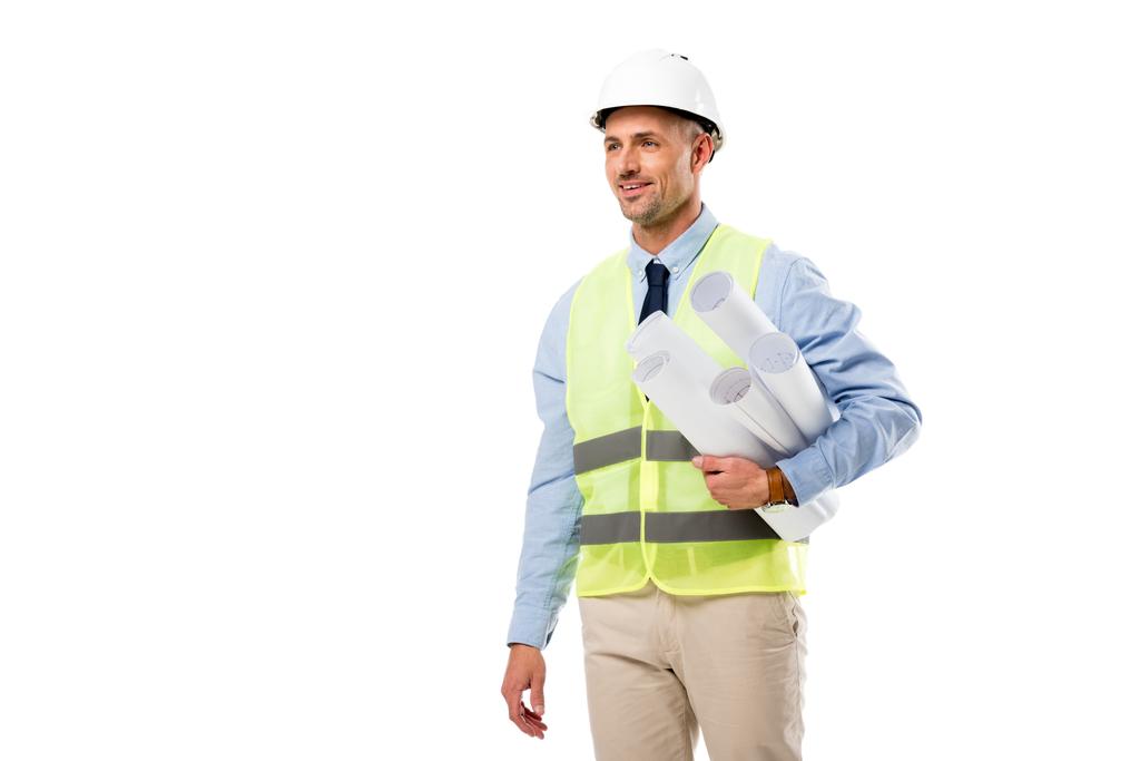 Lächelnder Ingenieur mit Bauplänen und isoliert auf weißem Grund wegschauendem Blick - Foto, Bild