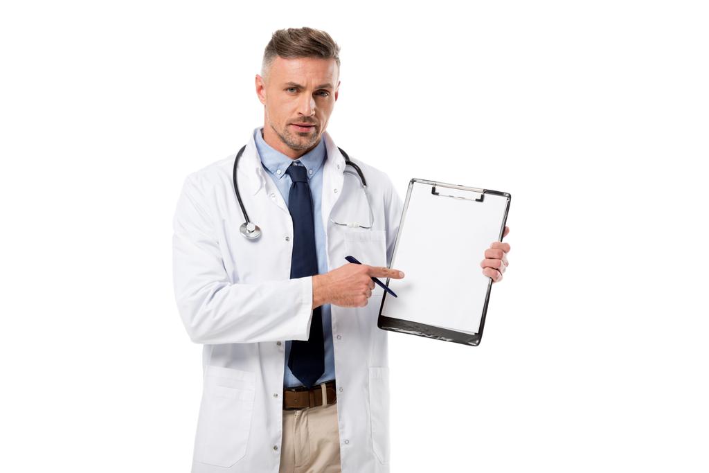 seriöser Arzt mit Stift, der in die Kamera schaut und auf die Diagnose zeigt, isoliert auf Weiß - Foto, Bild