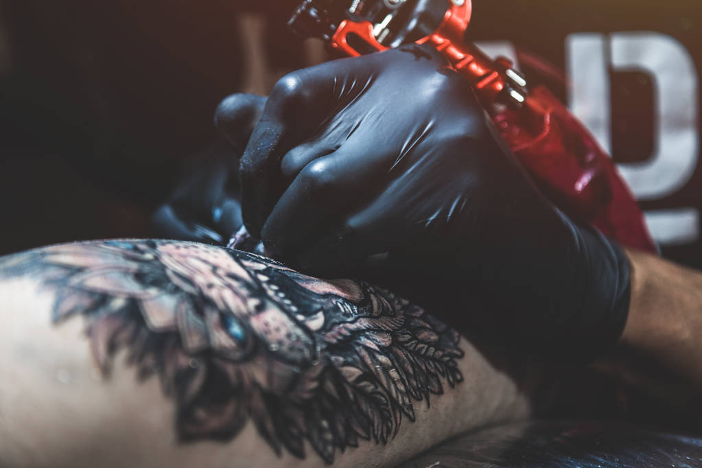 Tatuażysta tworzy obraz na organizm człowieka. zbliżenie do tatuażu i ręce - Zdjęcie, obraz