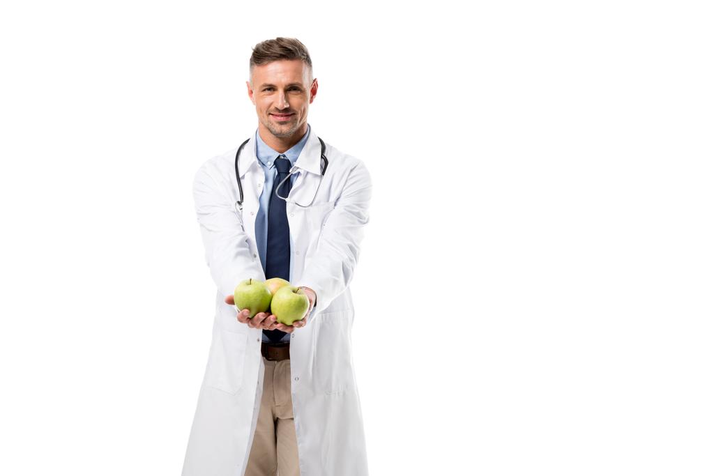 笑みを浮かべてカメラを見て、白、健康的な食事の概念に分離された新鮮なリンゴを保持している医師 - 写真・画像