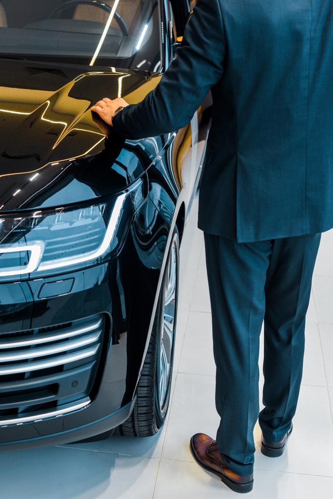 обрізане зображення бізнесмена, який вибирає автомобіль в салоні дилерів
 - Фото, зображення