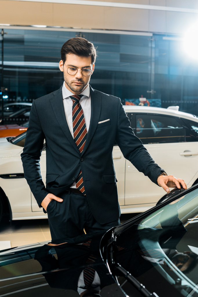 apuesto hombre de negocios en gafas de vista elegir el coche en salón de concesionarios
 - Foto, imagen