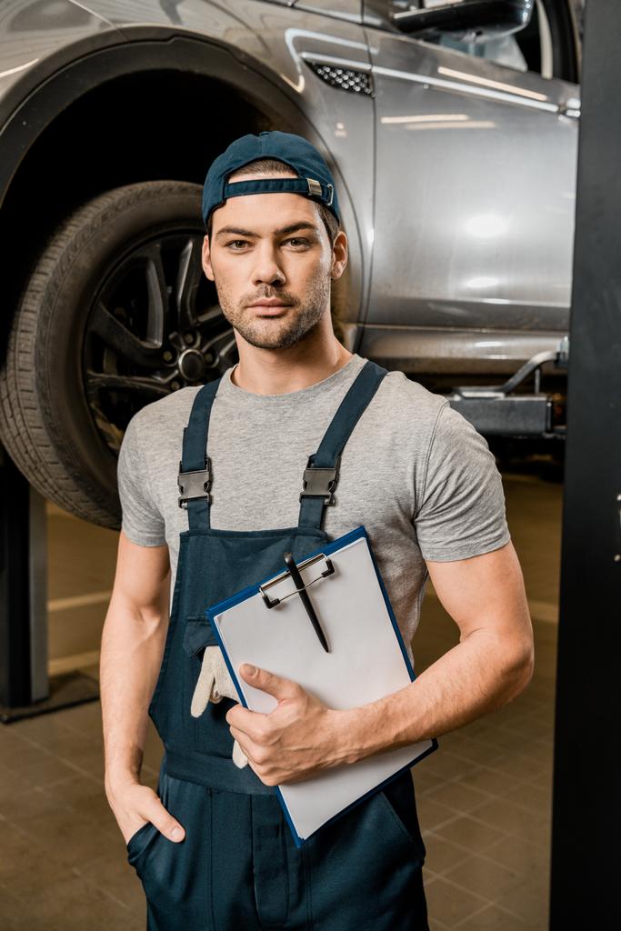 portrait of repairman with notepad at auto repair shop - Photo, Image