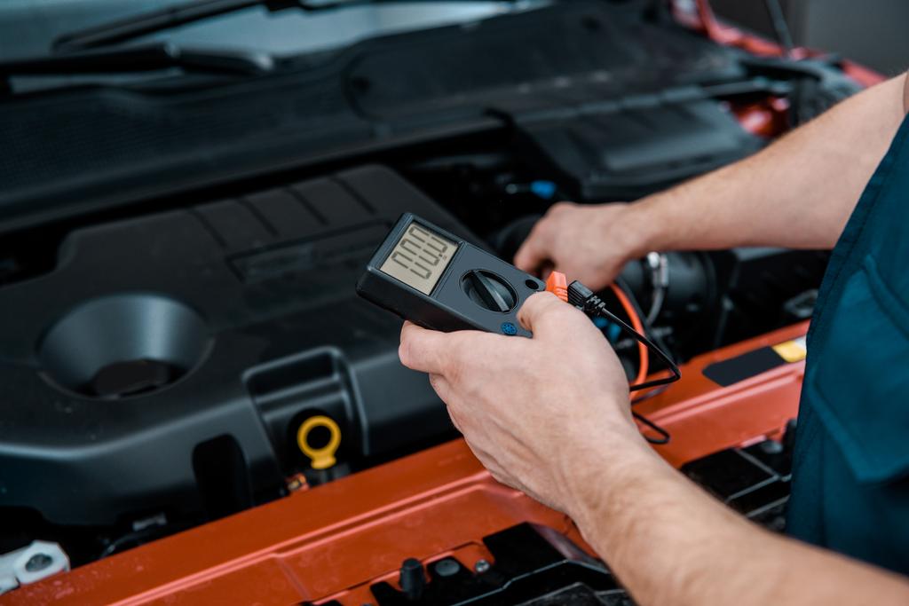 自動車整備士メカニック ショップで車のバッテリー電圧を確認デジタルマルチメータ電圧計での部分的なビュー - 写真・画像