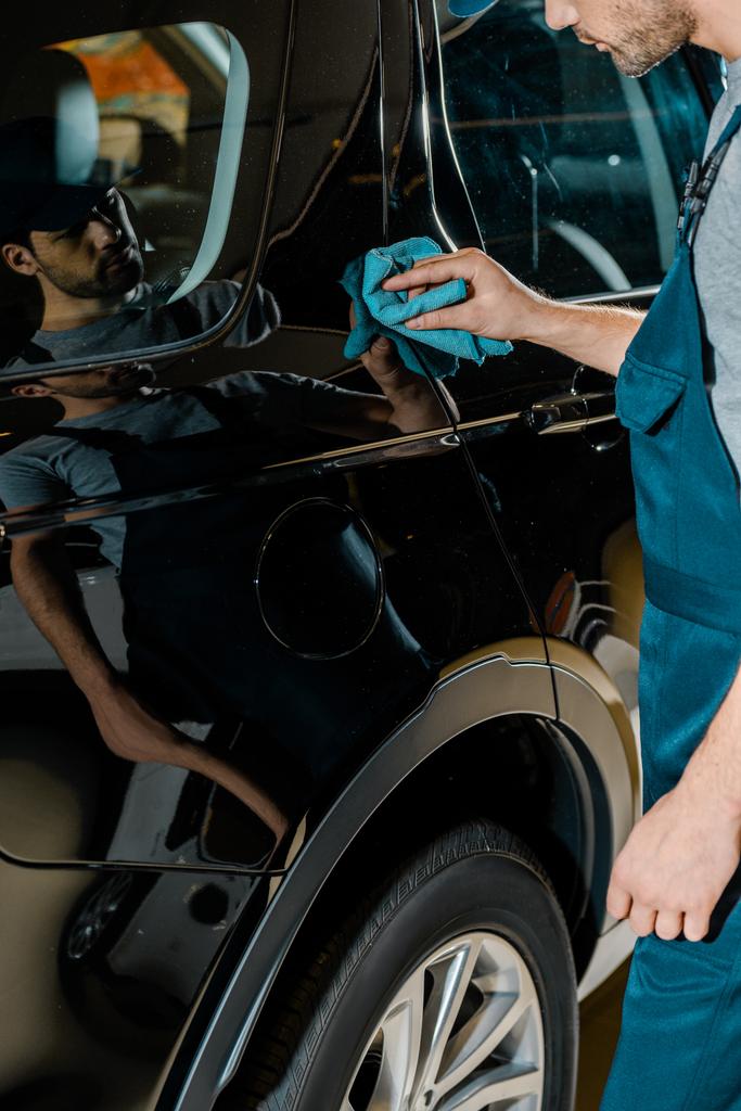 gedeeltelijke weergave van auto mechanisch reinigen auto met doek bij auto reparatiewerkplaats - Foto, afbeelding