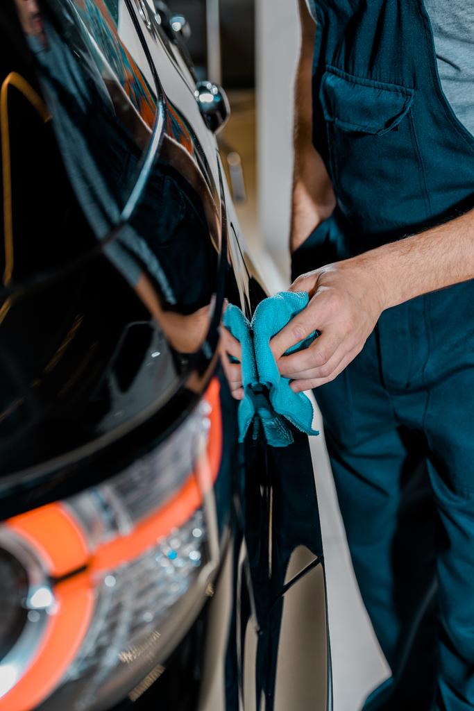 partial view of auto mechanic cleaning car with rag at auto repair shop - Photo, Image