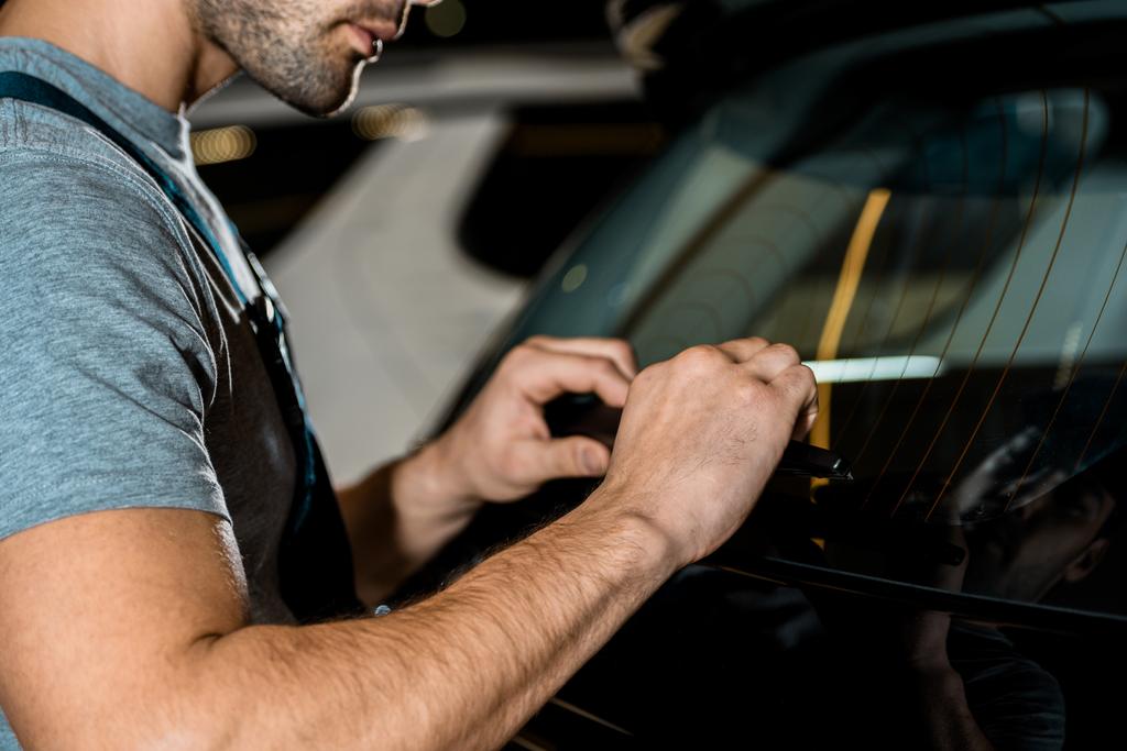 Teilansicht des Automechanikers bei der Überprüfung von Fahrzeugdetails im Mechaniker-Geschäft - Foto, Bild